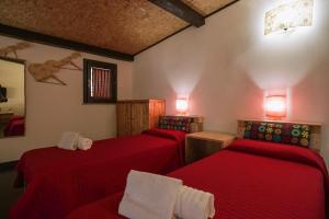 - 2 lits dans une chambre avec des draps rouges dans l'établissement dependance in villa con piscina, à Raguse