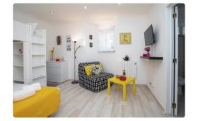 uma sala de estar com uma mesa amarela e uma cadeira em BeGuest Casetta Cleo em Albufeira