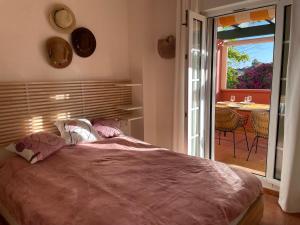 a bedroom with a bed and a balcony with a table at A charming 6-person apartment, golf, surfing, free tennis courts and bicycles in Isla Canela
