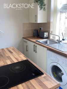 a kitchen with a sink and a washing machine at Cheerful one-bedroom house, with on-street parking by BPNE in Darlington