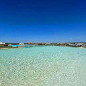 a large pool of water with a blue sky at Kapuhala Sicily in Marzamemi