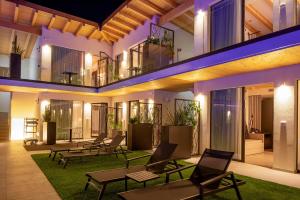 budynek z krzesłami i stołami na dziedzińcu w nocy w obiekcie Relais Limonaia - Suites & Garden SPA w mieście Torri del Benaco