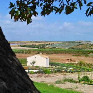 a white building in the middle of a field at Kapuhala Sicily in Marzamemi