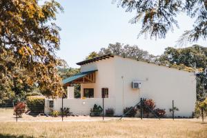a white house with a fence in front of it at Bergdale Cottages in Hazyview