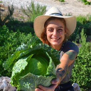 a woman in a hat holding a lettuce at Kapuhala Sicily in Marzamemi