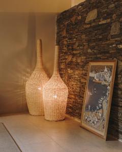 two vases sitting next to a brick wall with a picture at Hotel Llane Petit in Cadaqués