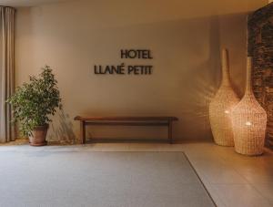 una habitación con dos jarrones y un banco en la pared en Hotel Llane Petit, en Cadaqués