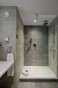 a bathroom with a shower with a sink and a shower at Maldron Hotel Manchester City Centre in Manchester