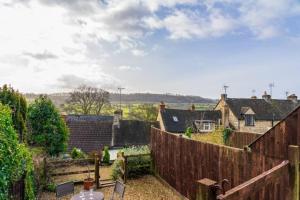 una vista desde el jardín de una casa con una valla en Teasel Cross Cottage, Painswick en Stroud