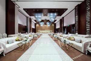 a large room with couches and tables and a hall at Rosh Rayhaan by Rotana in Riyadh