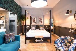 The Royal Elysée Suite في باريس: غرفة بسرير وأريكة زرقاء