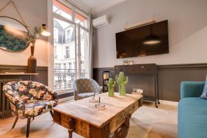 The Royal Elysée Suite في باريس: غرفة معيشة مع طاولة وأريكة