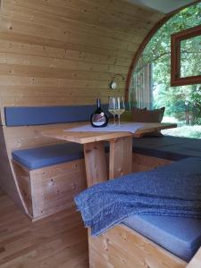 eine Holzhütte mit einem Tisch und einem Glas Wein in der Unterkunft Übernachten im Weinfass in Volkach