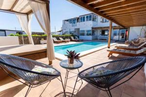 un patio avec deux chaises et une piscine dans l'établissement Apartamentos El Callao II Suites, à La Asomada