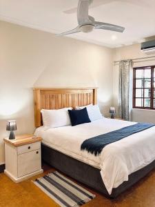 a bedroom with a large bed with a ceiling fan at Bergdale Cottages in Hazyview