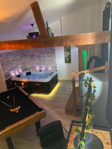 Pokój ze stołem bilardowym w pokoju z sufitem w obiekcie Le Cosily jacuzzi et sauna privatif w mieście Cuvilly