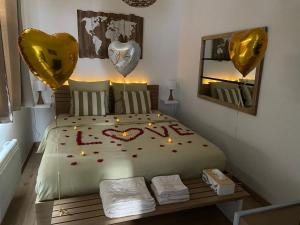sypialnia z łóżkiem, świecami i balonami w obiekcie Le Cosily jacuzzi et sauna privatif w mieście Cuvilly