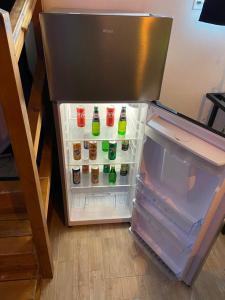an open refrigerator with drinks inside of it at Le Cosily jacuzzi et sauna privatif in Cuvilly