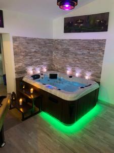 uma banheira de hidromassagem com luzes num quarto em Le Cosily jacuzzi et sauna privatif em Cuvilly