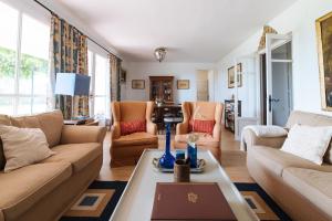 a living room with couches and a table at La casita de Hato Pinos, un rincón en Doñana in Aznalcázar
