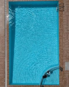 a blue pool of water with a shower head at Nefeli Beach - living by the sea in Argassi