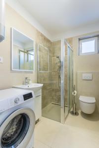 a washing machine in a bathroom with a shower at Apartman Vischetti in Cres +24 photos