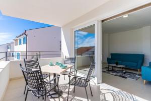 a balcony with a table and chairs and a couch at Apartman Vischetti in Cres