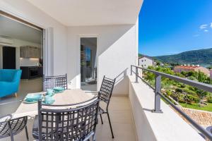 a balcony with a table and chairs with a view at Apartman Vischetti in Cres