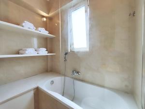 a bathroom with a bath tub and a window at Niovis B1 by Verde Apartments in Athens