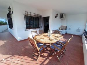 a dining room with a wooden table and chairs at House in a cove Almunecar in Almuñécar