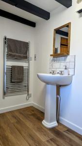 a bathroom with a white sink and a mirror at Yetland Farm Holiday Cottages in Combe Martin
