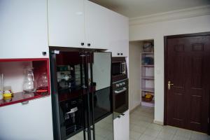 uma cozinha com um frigorífico preto e branco em Beautiful 4-Bedroom House Located in Abuja em Abuja