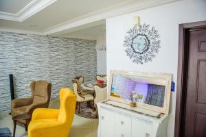 ein Wohnzimmer mit einem Tisch, Stühlen und einem Spiegel in der Unterkunft Beautiful 4-Bedroom House Located in Abuja in Abuja