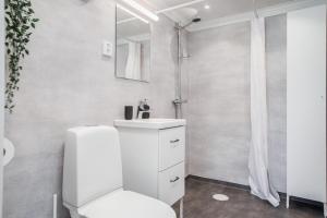 La salle de bains blanche est pourvue de toilettes et d'un lavabo. dans l'établissement Cozy holiday house close to nature in Ödeshög, Gränna, à Ödeshög