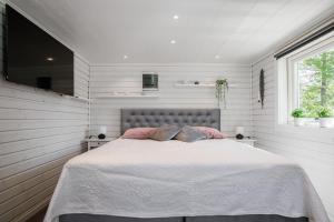 - une chambre dotée d'un lit avec des oreillers roses dans l'établissement Cozy holiday house close to nature in Ödeshög, Gränna, à Ödeshög