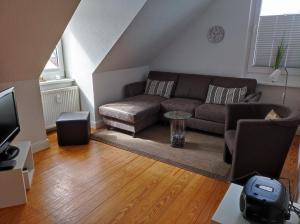 un salon avec un canapé et une télévision dans l'établissement Haus Sommerwind, à Norderney