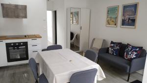 uma cozinha com uma mesa branca e cadeiras num quarto em Charmant et lumineux logement, au cœur de Cabourg em Cabourg