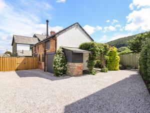 a brick house with a fence and a driveway at Little Nook in Corwen