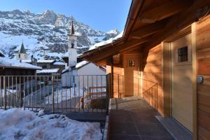 a house with a gate and a church in the snow at Il Cuore Del Cervino in Breuil-Cervinia