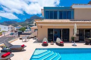 a villa with a swimming pool and a house at TORVISCAS SUNSET VILLA & Jacuzzi in Adeje