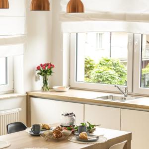 cocina con mesa, fregadero y ventanas en Morze Wrzosów LuxFlats, en Jastrzębia Góra
