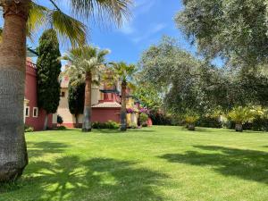 un patio con palmeras y una casa en A charming 6-person apartment, golf, surfing, free tennis courts and bicycles en Isla Canela