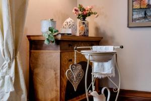 a wooden table with a sink and a vase of flowers at PALAZZO Bed and Breakfast in Calvisano