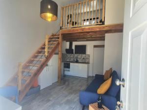 a living room with a blue couch and a staircase at Xagi House - Montargil in Montargil