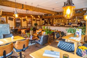 ein Restaurant mit Tischen und Stühlen und eine Bar in der Unterkunft EuroParcs Hoge Kempen in Zutendaal