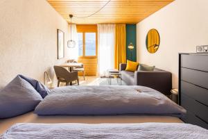 a bedroom with a bed and a living room at Seehotel Sternen in Brienz