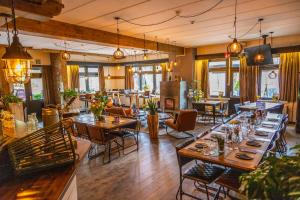 a restaurant with tables and chairs in a room at EuroParcs Hoge Kempen in Zutendaal