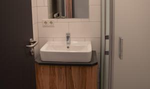 a bathroom with a white sink and a door at Gasthof zur Post in Lalling