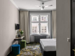 um quarto de hotel com uma cama e uma janela em numa l Root Rooms & Apartments em Praga