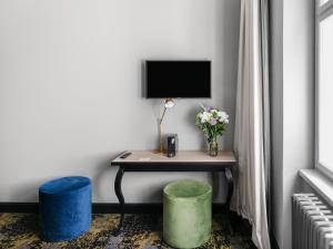 a room with a desk with a television and two stools at Numa Prague Root in Prague